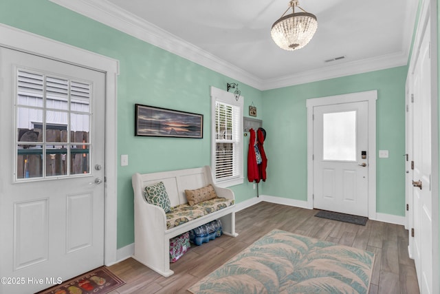 910 Old Dow Rd, Carolina Beach, NC 28428 - entrance foyer featuring plenty of natural light, a chandelier, crown molding, wood finished floors, and baseboards