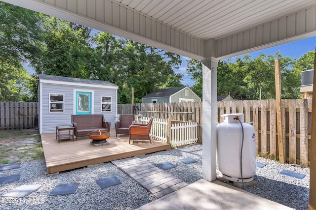 910 Old Dow Rd, Carolina Beach, NC 28428 - wooden deck featuring a fenced backyard, an outbuilding, and an outdoor fire pit