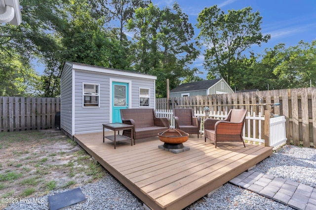 910 Old Dow Rd, Carolina Beach, NC 28428 - deck with an outdoor fire pit, a fenced backyard, and an outbuilding