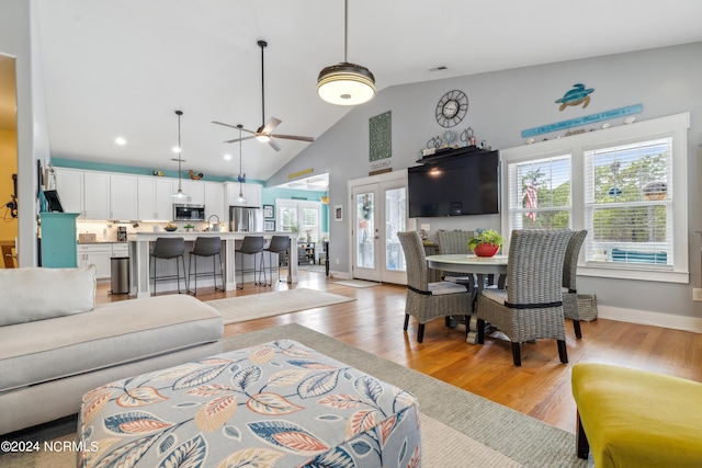 living room with high vaulted ceiling, light hardwood / wood-style flooring, ceiling fan, and sink