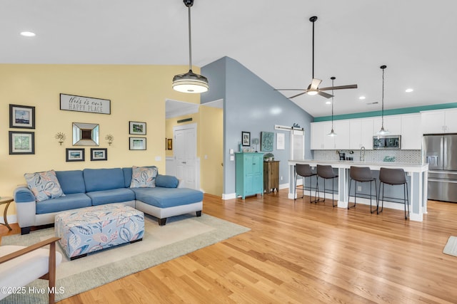 910 Old Dow Rd, Carolina Beach, NC 28428 - living room with a barn door, light wood-style flooring, a ceiling fan, baseboards, and recessed lighting