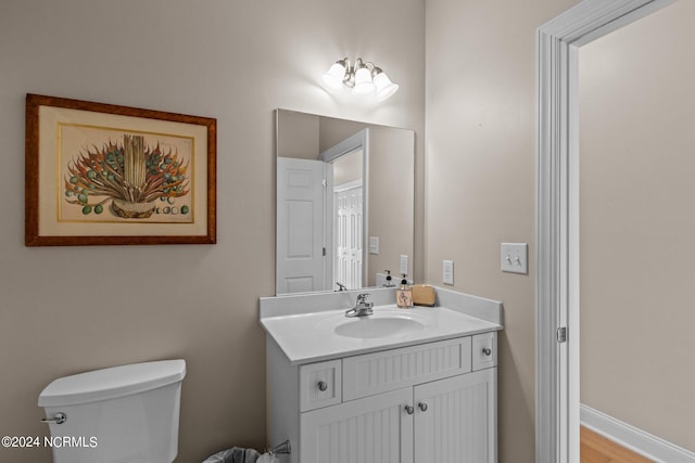 bathroom featuring wood-type flooring, vanity, and toilet