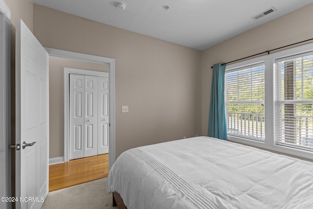 bedroom with light hardwood / wood-style flooring and a closet