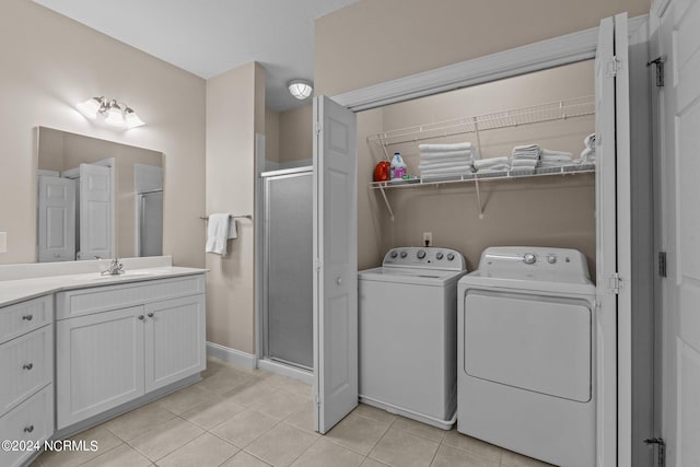 clothes washing area with light tile patterned floors, sink, and independent washer and dryer