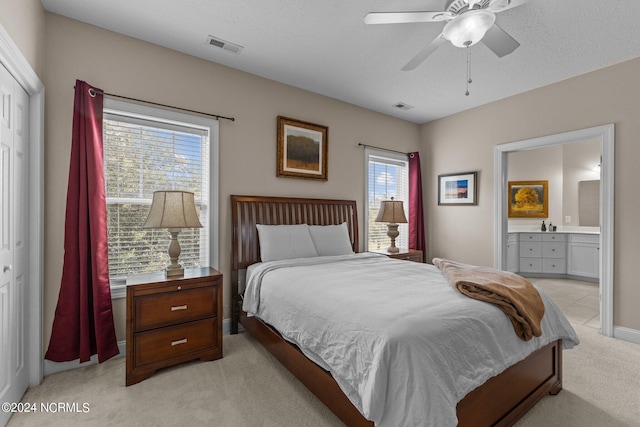 carpeted bedroom with ceiling fan, a closet, connected bathroom, and multiple windows