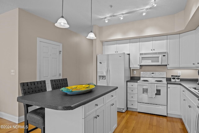 kitchen featuring light wood-type flooring, white appliances, white cabinetry, and pendant lighting