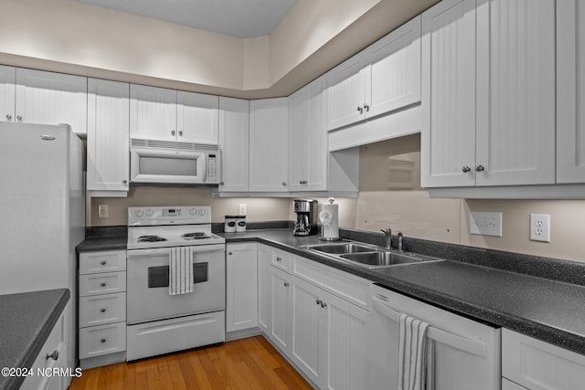 kitchen featuring light wood-type flooring, white appliances, white cabinetry, and sink