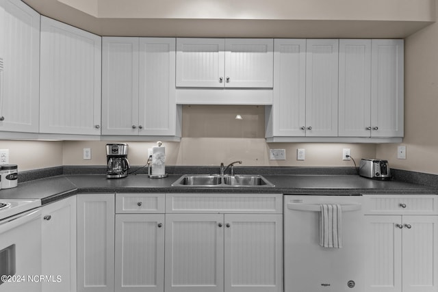 kitchen with white appliances, white cabinetry, and sink