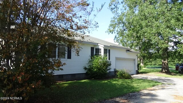 view of side of home with a garage and a yard