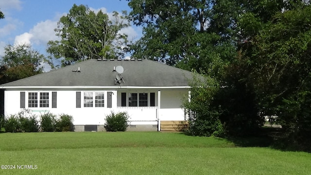 rear view of property with a yard