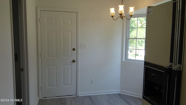 foyer entrance with wood-type flooring and a notable chandelier