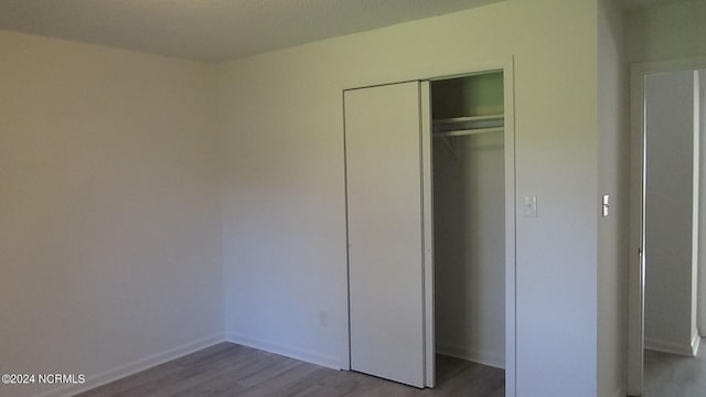 unfurnished bedroom with light hardwood / wood-style floors and a closet