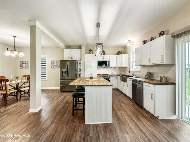 kitchen featuring wooden counters, a healthy amount of sunlight, stainless steel appliances, and a kitchen island