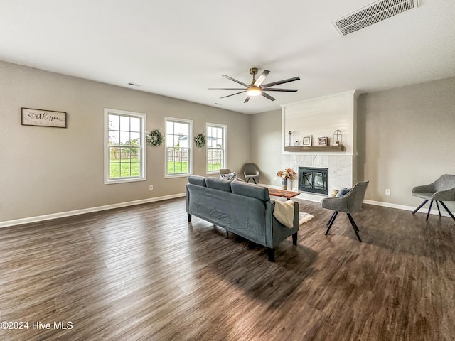 living room featuring ceiling fan, dark hardwood / wood-style floors, and a fireplace