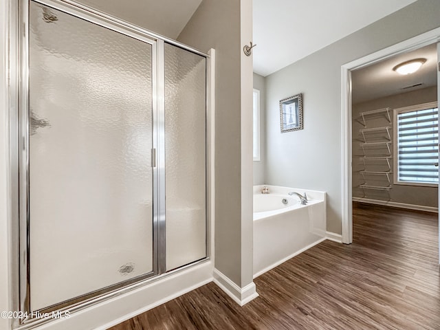 bathroom featuring plus walk in shower and wood-type flooring