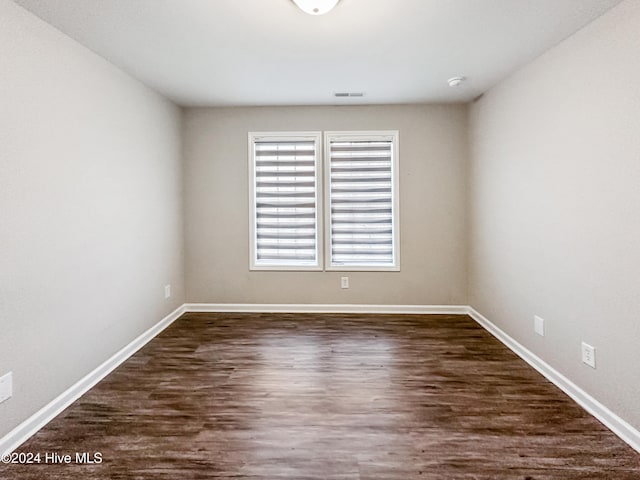 unfurnished room featuring dark wood-type flooring