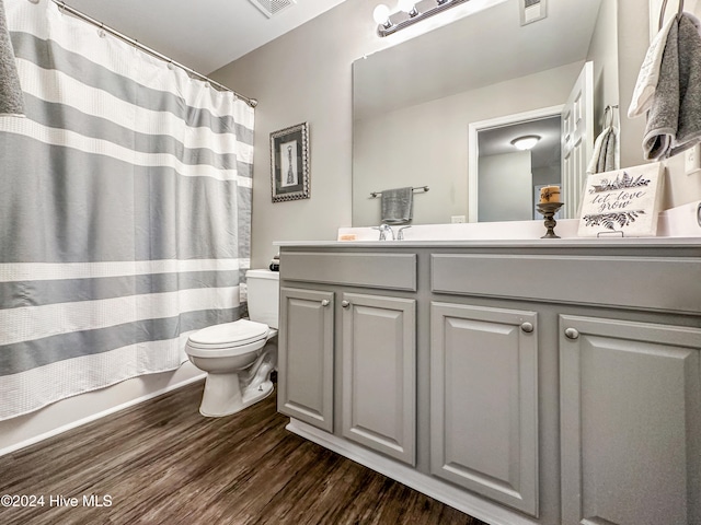 bathroom featuring vanity, hardwood / wood-style floors, curtained shower, and toilet