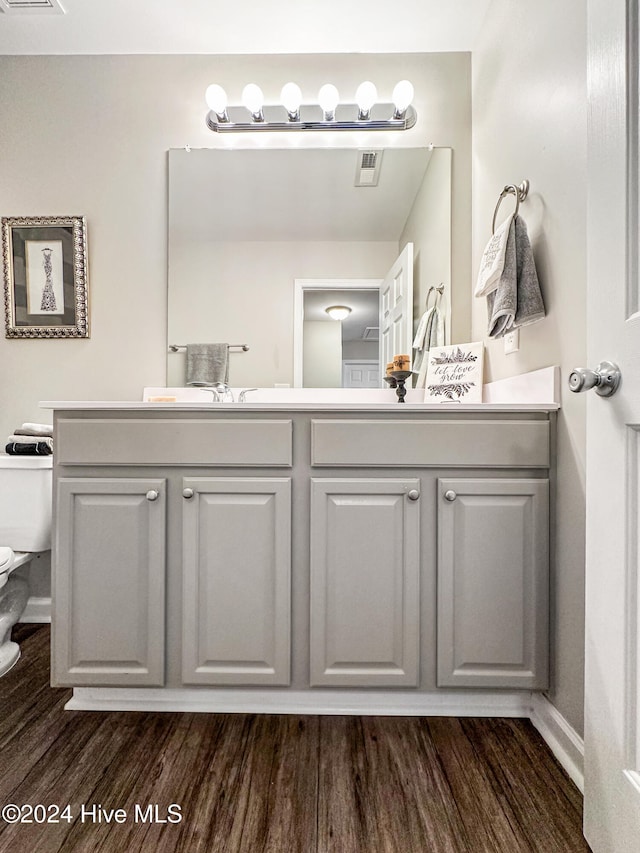 bathroom with vanity, hardwood / wood-style floors, and toilet