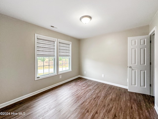 empty room with dark hardwood / wood-style flooring