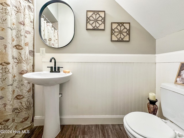 bathroom featuring toilet, hardwood / wood-style flooring, and lofted ceiling