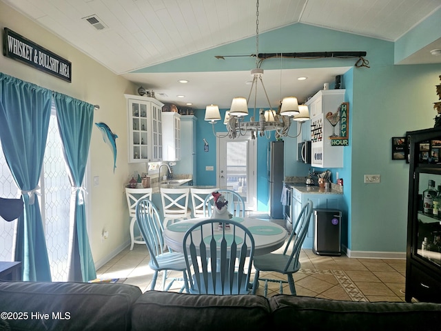 dining room with wood ceiling, vaulted ceiling, a wealth of natural light, and light tile patterned floors