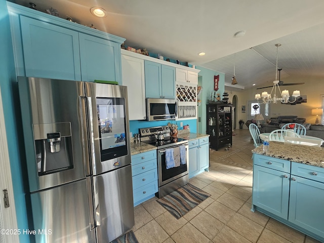 kitchen featuring light tile patterned flooring, blue cabinetry, lofted ceiling, and appliances with stainless steel finishes