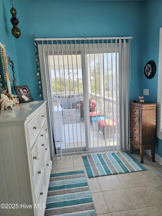 doorway with light tile patterned floors and a wealth of natural light