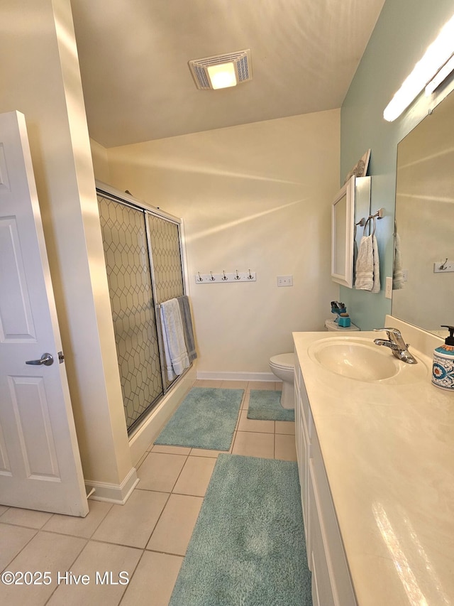 bathroom featuring vanity, walk in shower, tile patterned floors, and toilet