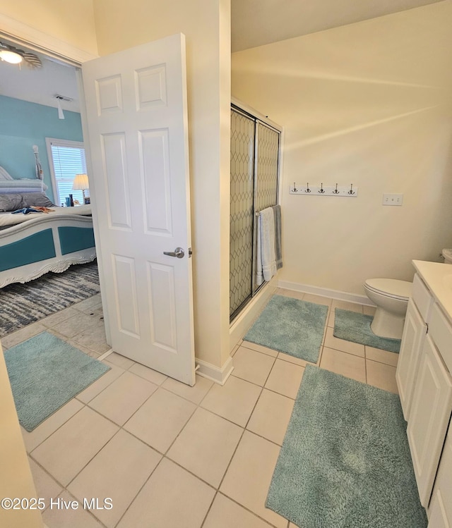 bathroom featuring toilet, an enclosed shower, tile patterned floors, and vanity