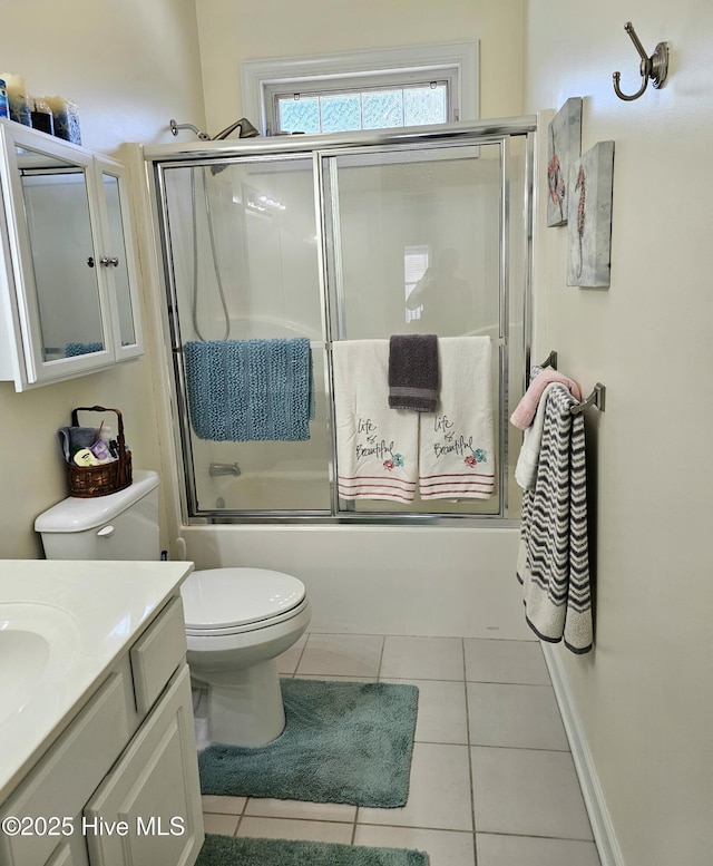 full bathroom featuring vanity, toilet, combined bath / shower with glass door, and tile patterned flooring