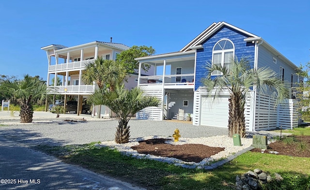 raised beach house featuring a balcony and a garage