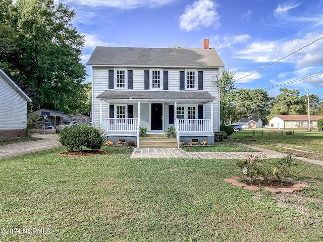 view of front facade featuring covered porch and a front yard