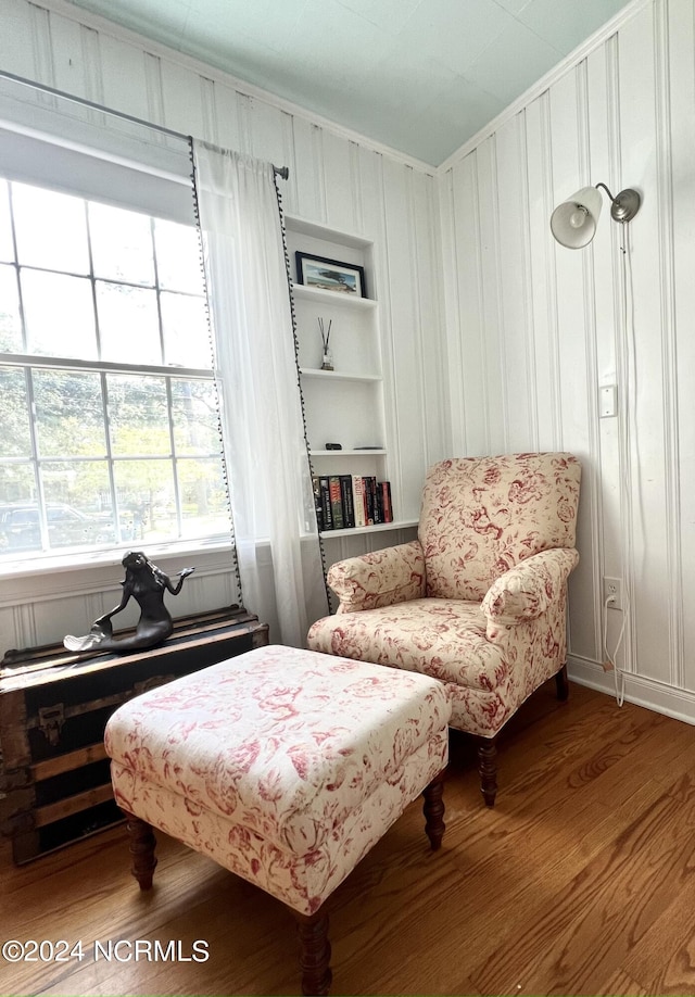 sitting room with built in features and hardwood / wood-style floors