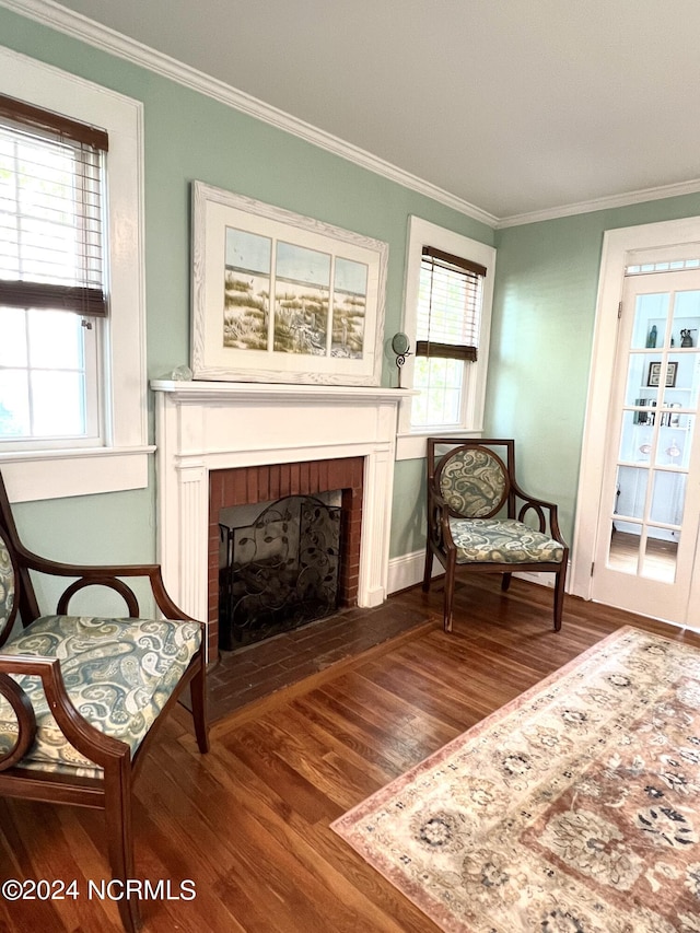 living area with hardwood / wood-style floors, a fireplace, and crown molding