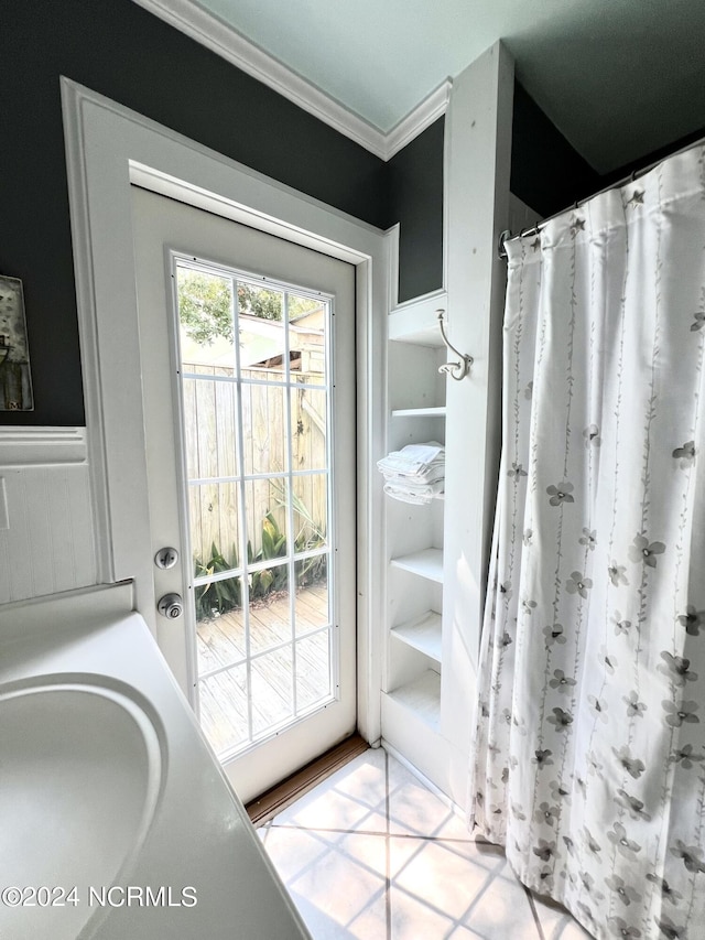 bathroom with tile patterned flooring, walk in shower, and crown molding