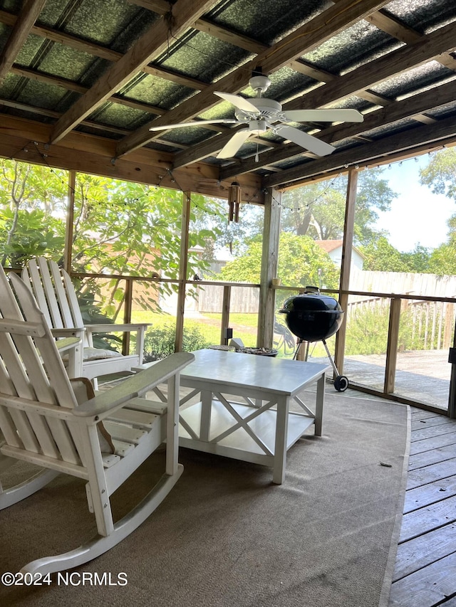 unfurnished sunroom featuring ceiling fan