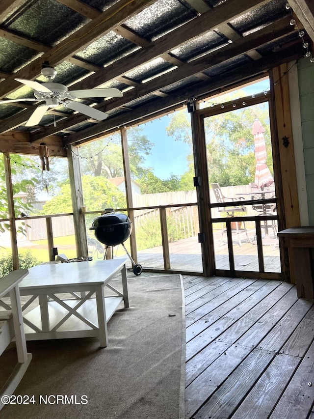 unfurnished sunroom with ceiling fan and plenty of natural light