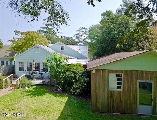 exterior space with an outbuilding, a yard, and a patio area