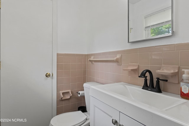 bathroom with tile walls, vanity, and toilet