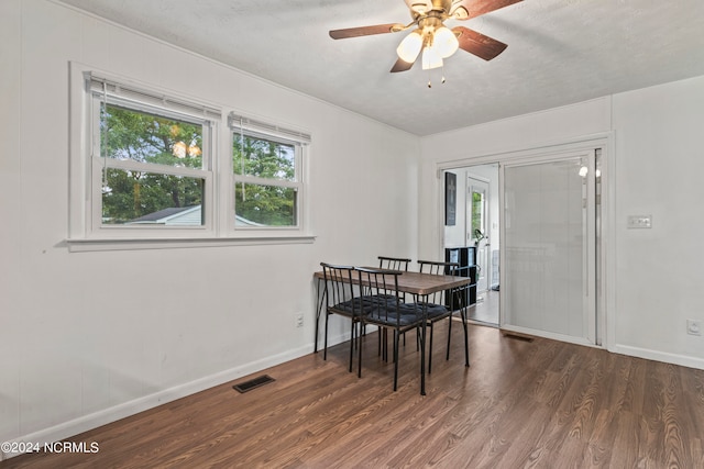 dining room featuring a textured ceiling, ceiling fan, and dark wood-type flooring