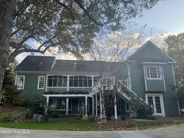 view of front of house featuring a sunroom, a patio area, and french doors