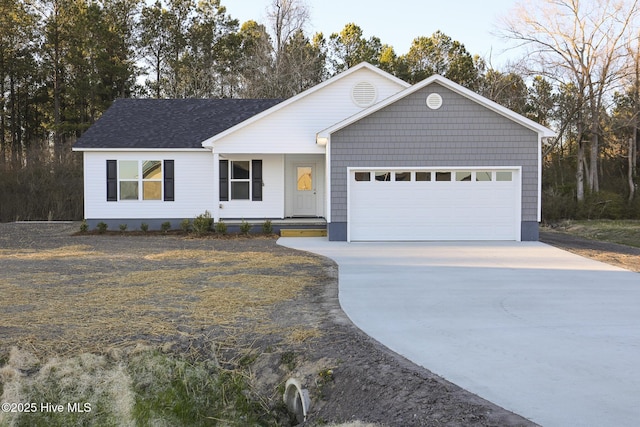 ranch-style home featuring concrete driveway, roof with shingles, and an attached garage