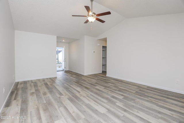 unfurnished room with light wood-style floors, vaulted ceiling, baseboards, and ceiling fan