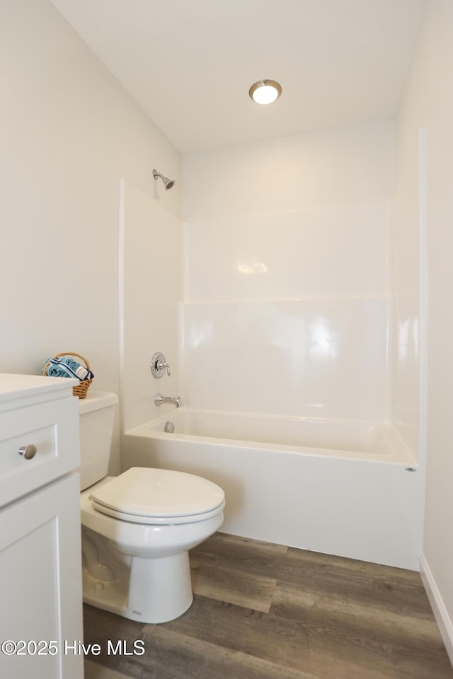 full bathroom with shower / bathtub combination, vanity, wood finished floors, and toilet