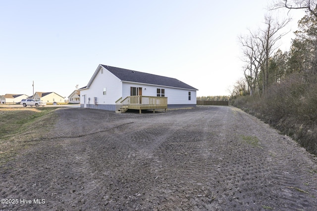 view of front of home featuring driveway and a deck