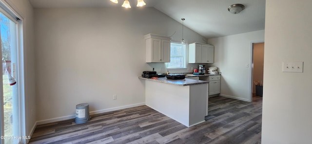 kitchen featuring decorative light fixtures, white cabinetry, dark wood-type flooring, and vaulted ceiling