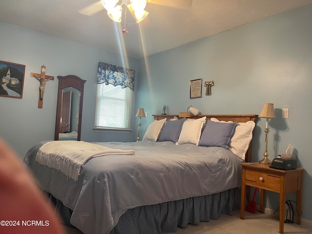 bedroom featuring ceiling fan, light colored carpet, and vaulted ceiling