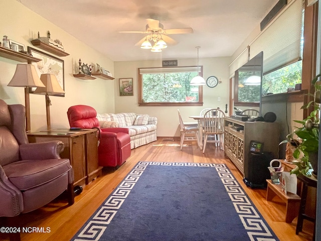 living room featuring wood-type flooring and ceiling fan