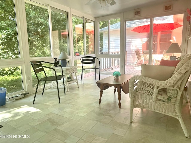 sunroom / solarium featuring a healthy amount of sunlight and ceiling fan