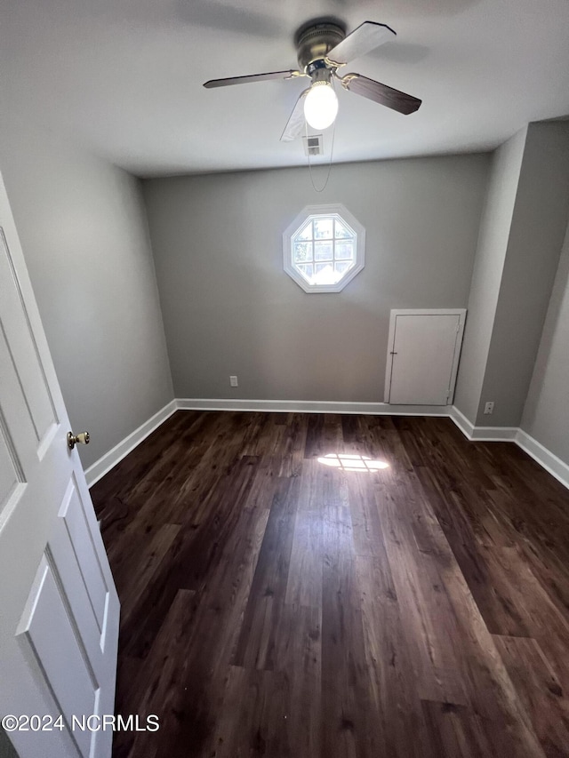 unfurnished room with dark wood-type flooring and ceiling fan